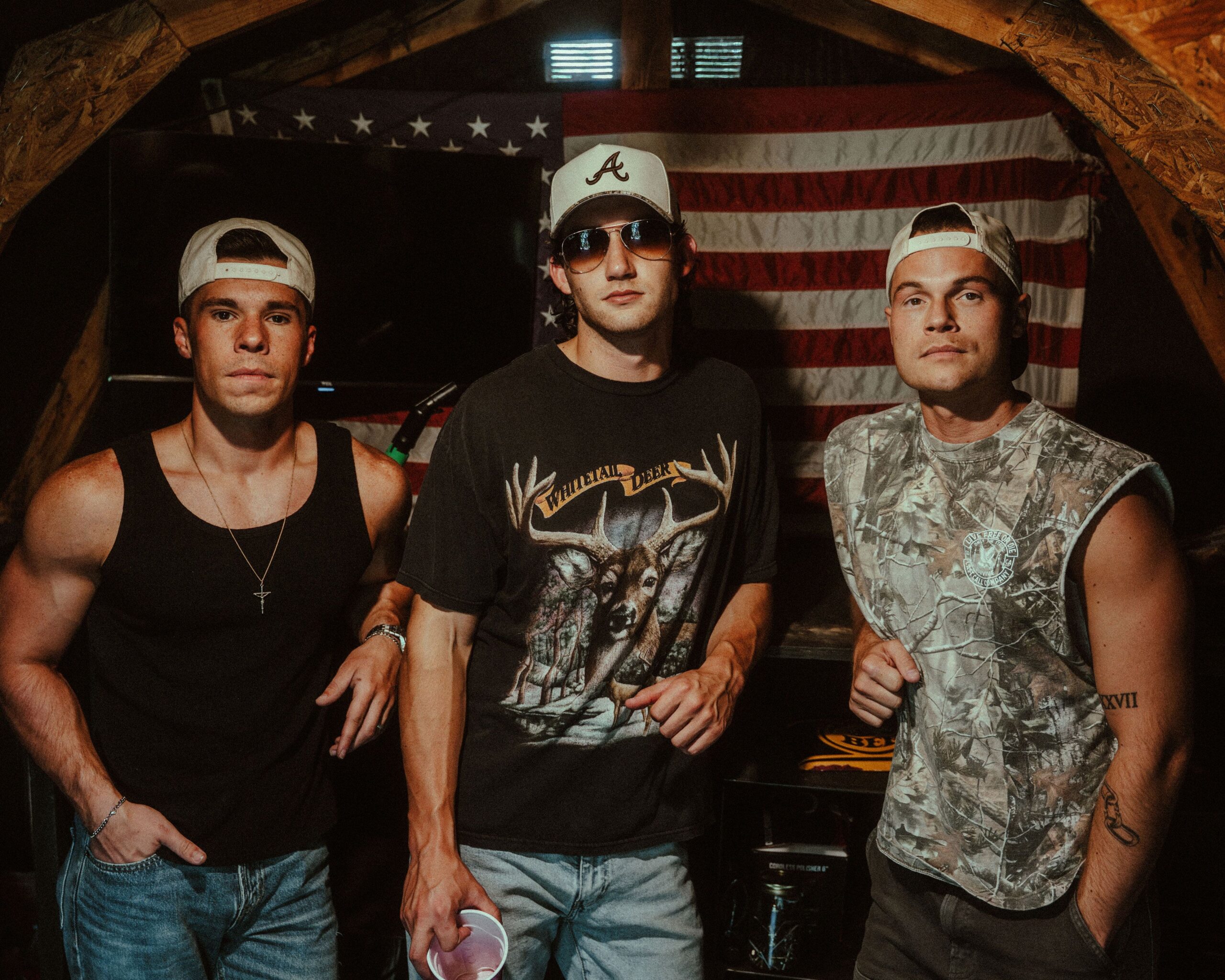 The three members of Deltona standing in front of an American flag
